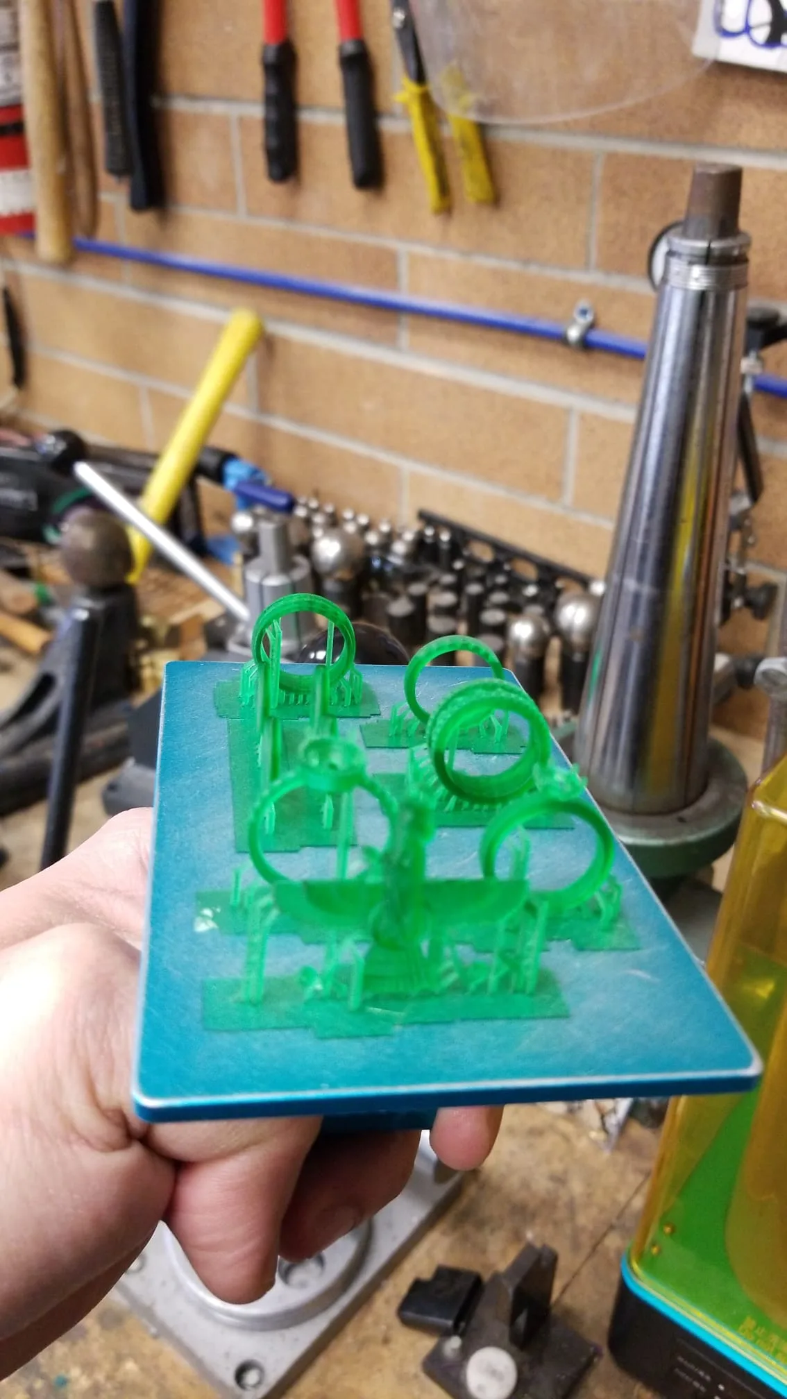 Resin 3D printer beside bench tools at a predecessor workshop